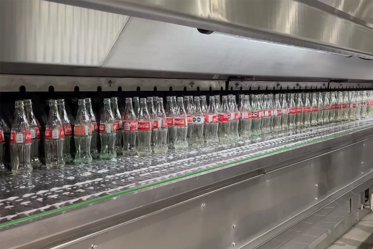 Esteira automatizada para envase de garrafas, ilustrando automação e produtividade.