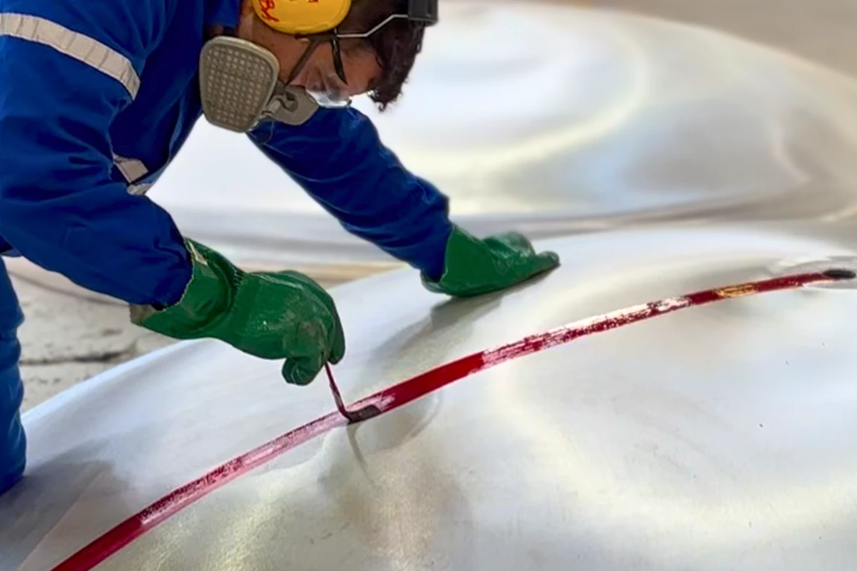 Profissional especializado executando soldagem em aço inoxidável, assegurando qualidade em montagem de equipamentos.
