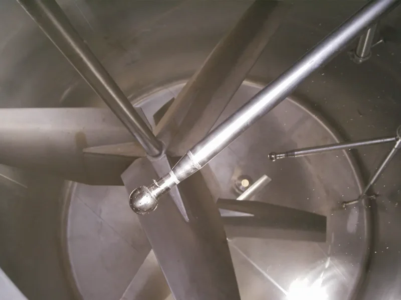 Interior de tanque industrial com misturador, evidenciando precisão nos processos e automação.